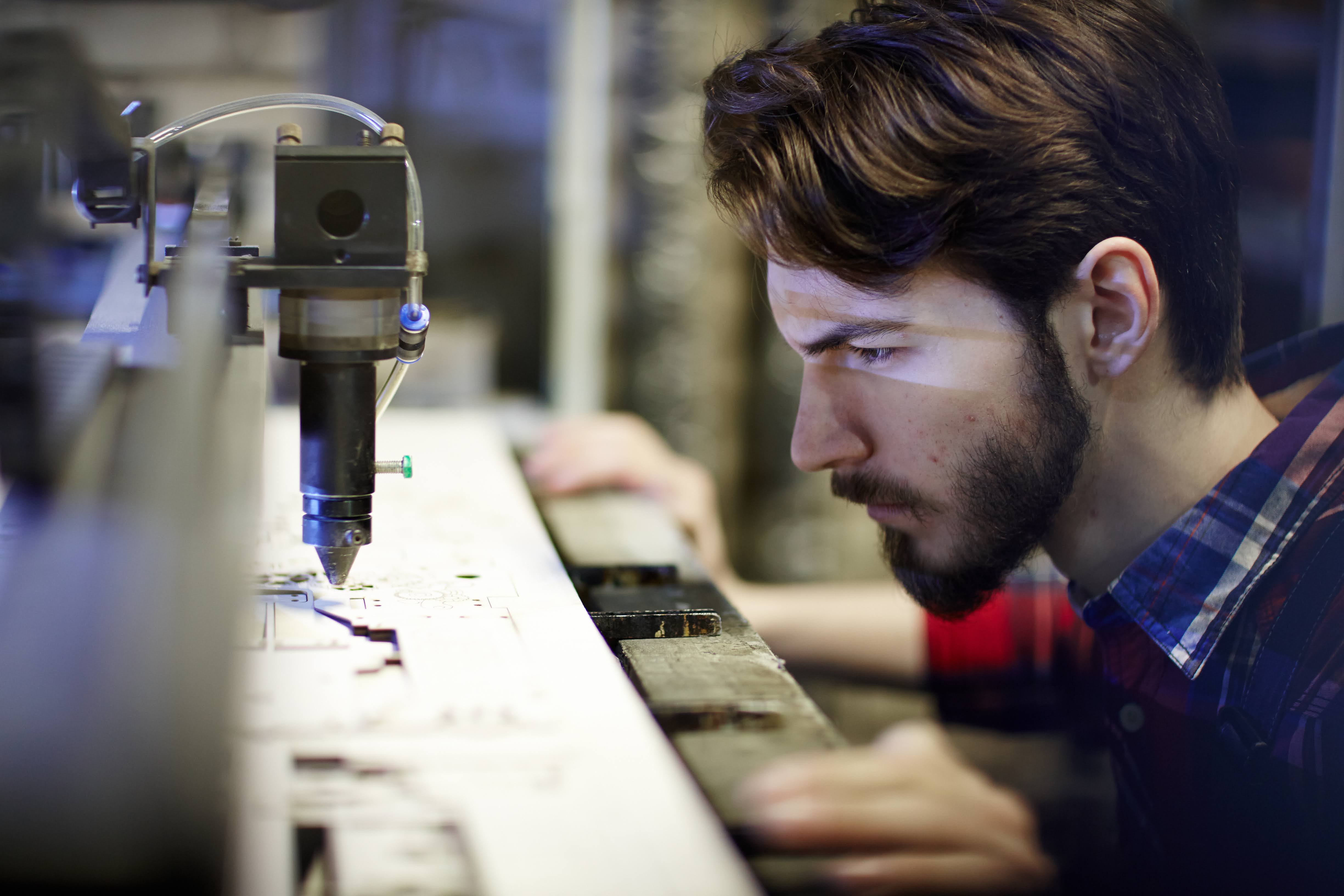 Lasersheet laser cutter maker inspecting machine while cutting wood